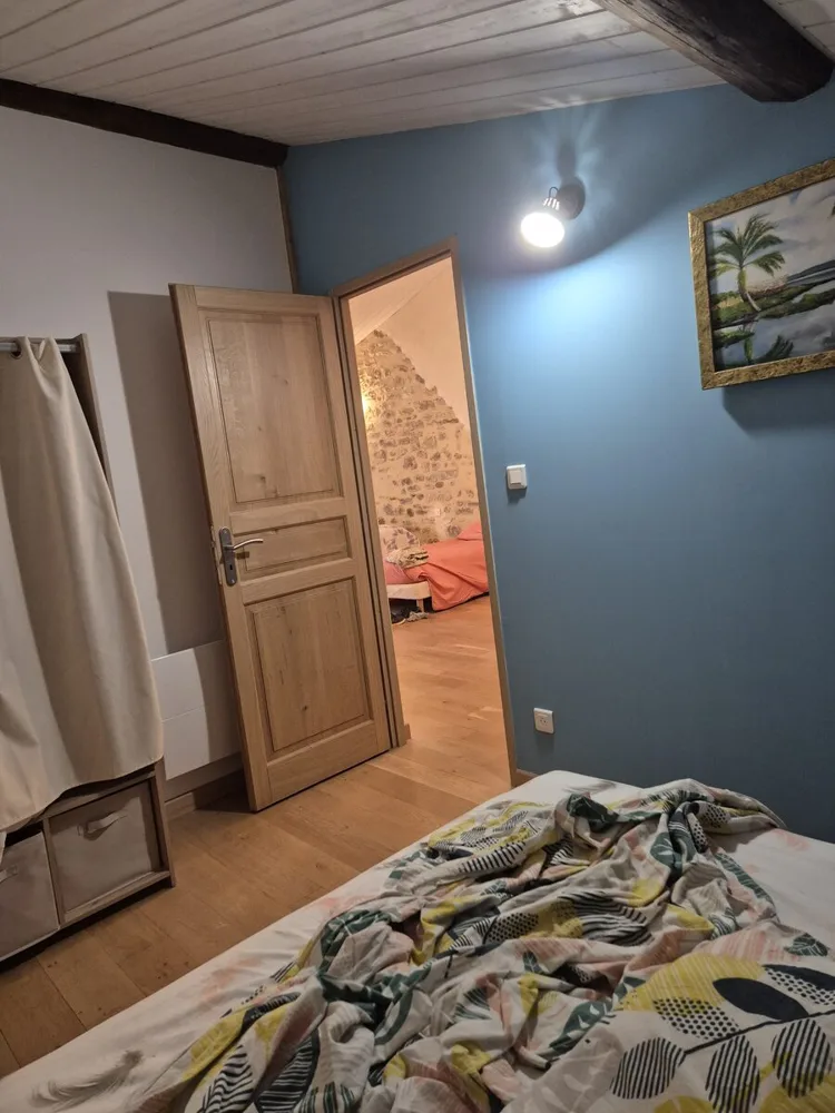 Chambre aux murs bleu canard et porte en chêne