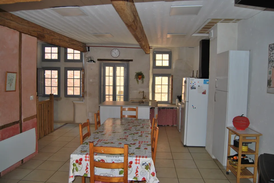 Large dining table in front of the small-paned kitchen windows