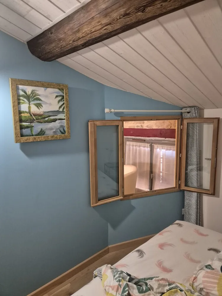 Petite chambre avec fenêtre intérieure donnant sur le palier